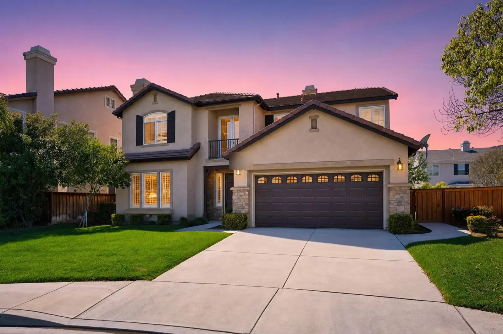 Two-story stucco home at dusk in the Twilight style, windows lit, with a virtual sky